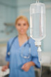 Focus on an intravenous drip next to a nurse
