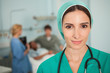 Nurse looking at camera next to a medical bed