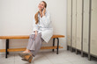 Smiling doctor sitting on a bench while calling