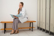 Doctor sitting on a bench while reading a folder