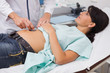 Doctor auscultating the patient belly with a stethoscope