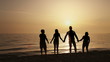 Four friends jumping on the beach at sunset