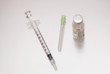 Syringe next to a drug bottle