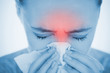 Woman blowing her nose with highlighted red sinus pain