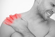 Man wincing in pain at sore shoulder