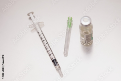 Photo: Syringe next to a drug bottle Syringe next to a drug bottle