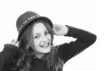 Young girl smiling and putting on her hat