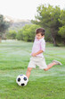 Little boy kicking football