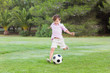 Little boy kicking his football