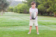 Smiling boy holding out rugby ball