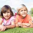 Smiling brother and sister lying on a blanket