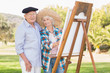 Portrait of older couple painting in the park