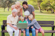 Multi-generation family in the park using laptop