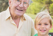 Portrait of grandfather and grandson in the park close up