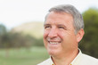 Smiling grey haired man looking into distance