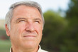 Thoughtful grey haired man looking into distance