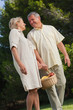 Happy older couple walking with basket of fruit