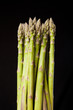 Bunch of fresh green asparagus on black background