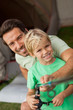 Portrait of father showing young son how to fish