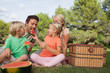 Happy family having a picnic and eating watermelon