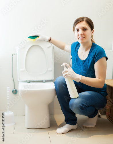 Photo: woman in bathroom with sponge and cleaner woman in bathroom with sponge and cleaner