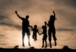 Family jumping together at sunset in the park