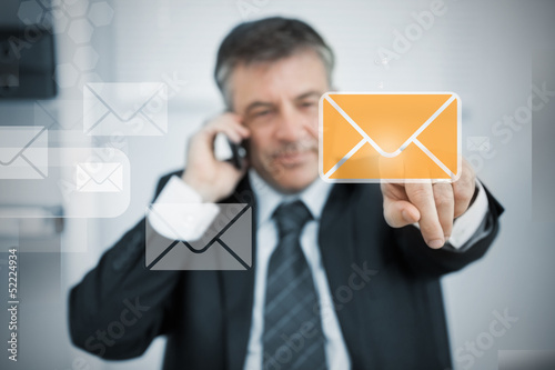 Photo: Businessman selecting new mail symbol on touchscreen Businessman selecting new mail symbol on touchscreen