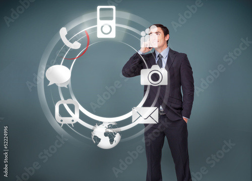 Photo: Businessman on the phone looking at wheel of applications Businessman on the phone looking at wheel of applications
