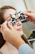 Optician putting trial glasses in trial frame