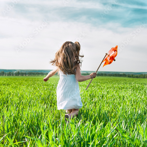 Photo: girl with a windmill in hand girl with a windmill in hand