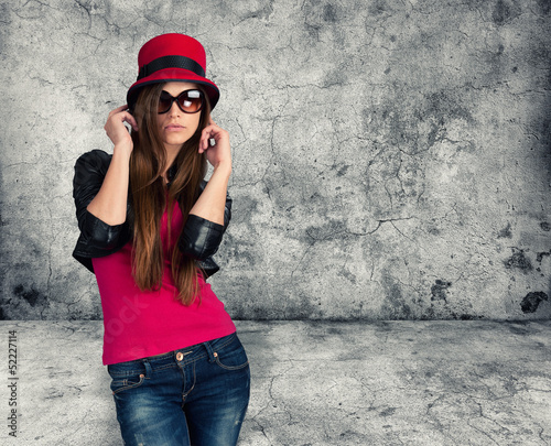 Photo: sexy stylish girl. Gray concrete wall sexy stylish girl. Gray concrete wall