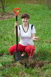 Female gardener planting tree