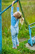 little girl hanging on old exercise equipment