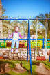 little girl on swing in children's city park
