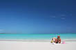 Girl with a glass of orange juice on the beach of Exuma, Bahamas