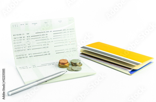 Photo: Coins and pen on account passbook isolate Coins and pen on account passbook isolate