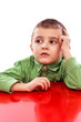 Pensive little boy looking in the air while holding hand on his