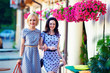 Foto: two smiling woman friends walking the summer city two smiling woman friends walking the summer city