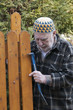 old man with kufi hat and tools repairing a gate