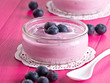 Joghurt mit Heidelbeeren auf einem Holztablett.