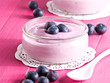 Joghurt mit Heidelbeeren auf einem Holztablett.