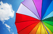 Rainbow umbrella on sky background
