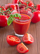 Tomatensaft mit frischen Tomaten im Hintergrund.