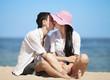 Photo: Beautiful couple kissing on the beach. Beautiful couple kissing on the beach.