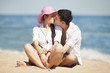 Photo: Beautiful couple kissing on the beach. Beautiful couple kissing on the beach.