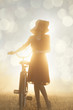 Photo: Girl on a bike in the countryside in sunrise time Girl on a bike in the countryside in sunrise time