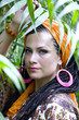 Blue-eyed woman with the african pigtails among tropical plants