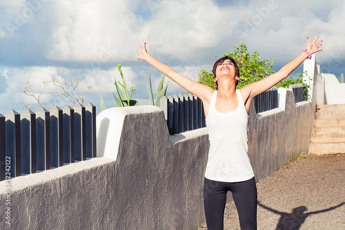 Photo: Happy woman standing with outstretched arms Happy woman standing with outstretched arms