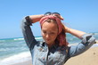 Beautiful redhead woman with scarf, having fun at the beach