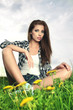 Portrait of young beautiful brunette woman  sitting on grass